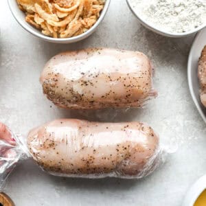 2 rolled stuffed chicken breasts tightly wrapped in plastic wrap.