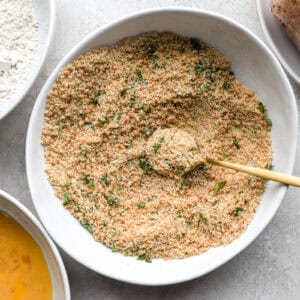 seasoned breadcrumbs in a bowl with a spoon.