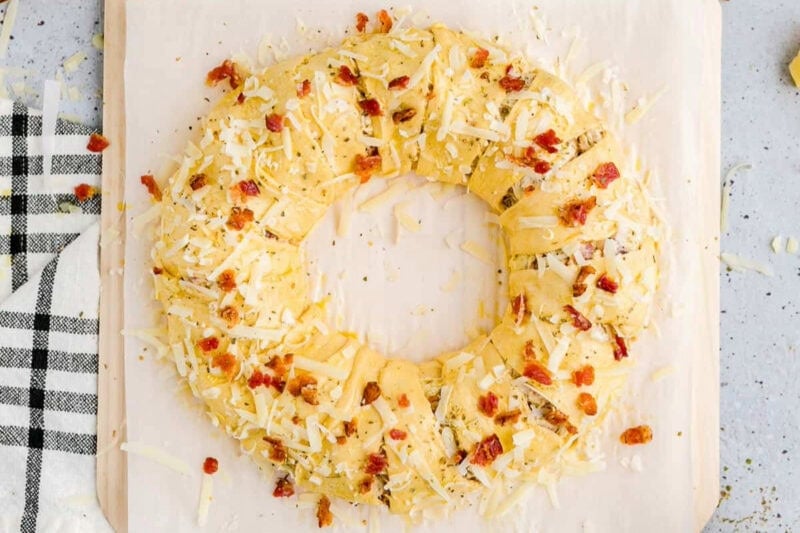 rolled-up chicken alfredo crescent roll topped with bacon and cheese.