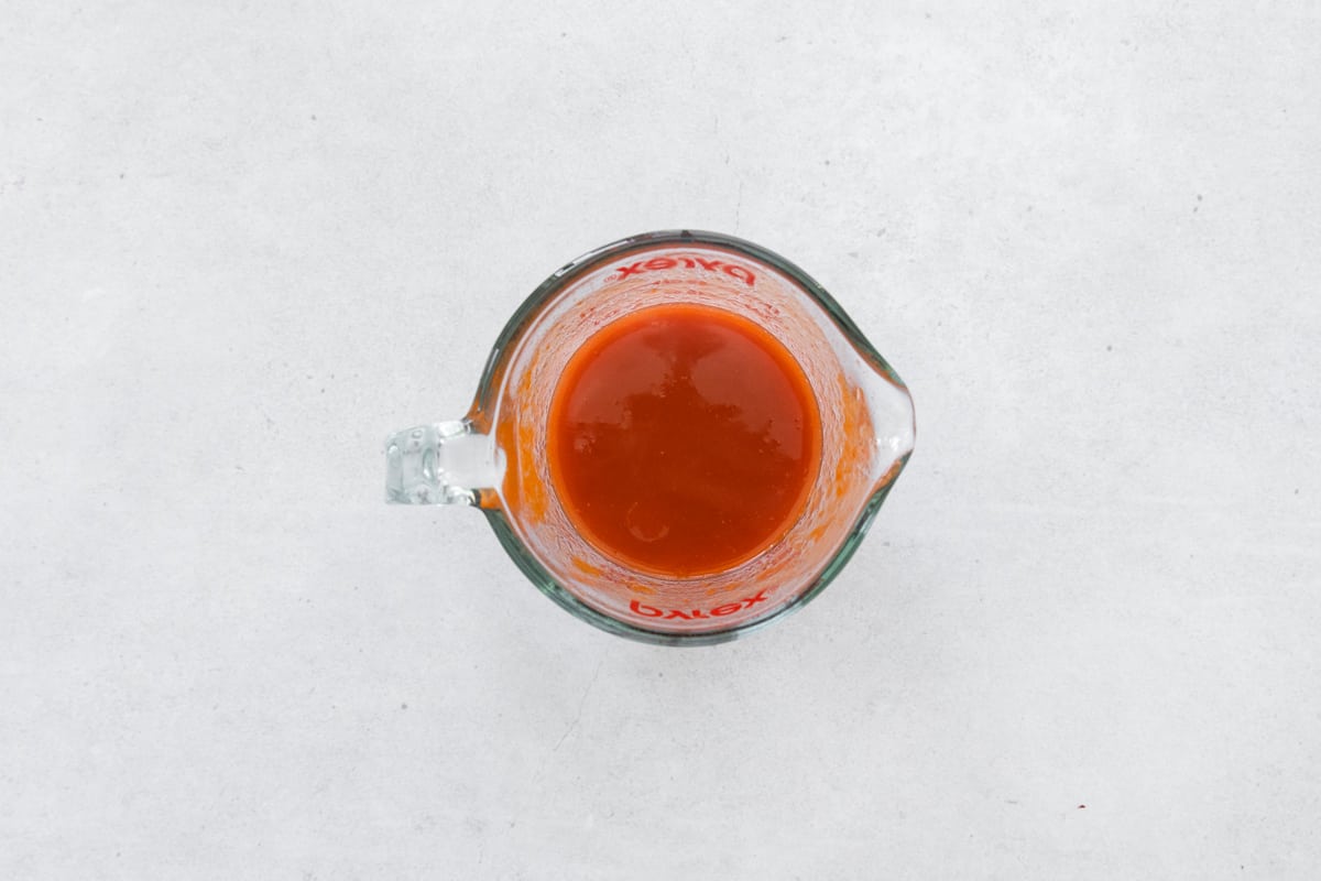 honey buffalo sauce in a glass measuring cup