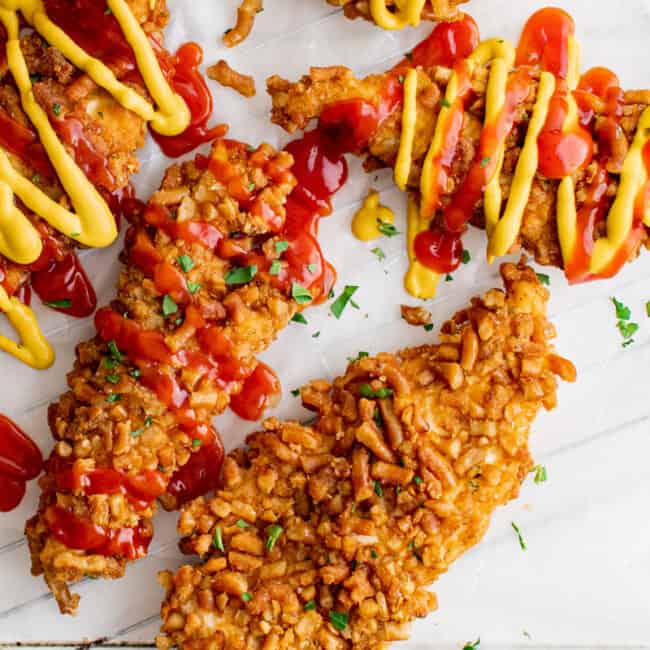 overhead image of pretzel chicken tenders with drizzle of ketchup and mustard