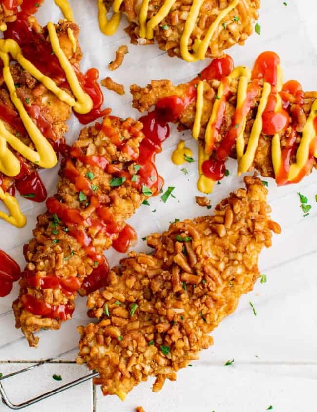 overhead image of pretzel chicken tenders with drizzle of ketchup and mustard