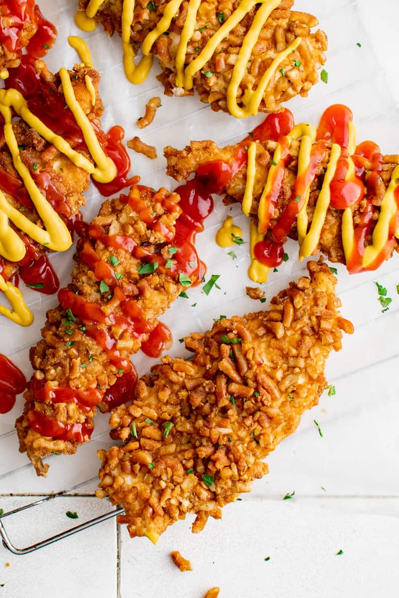 overhead image of pretzel chicken tenders with drizzle of ketchup and mustard