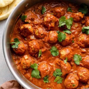 overhead view of butter chicken meatballs in a pan.