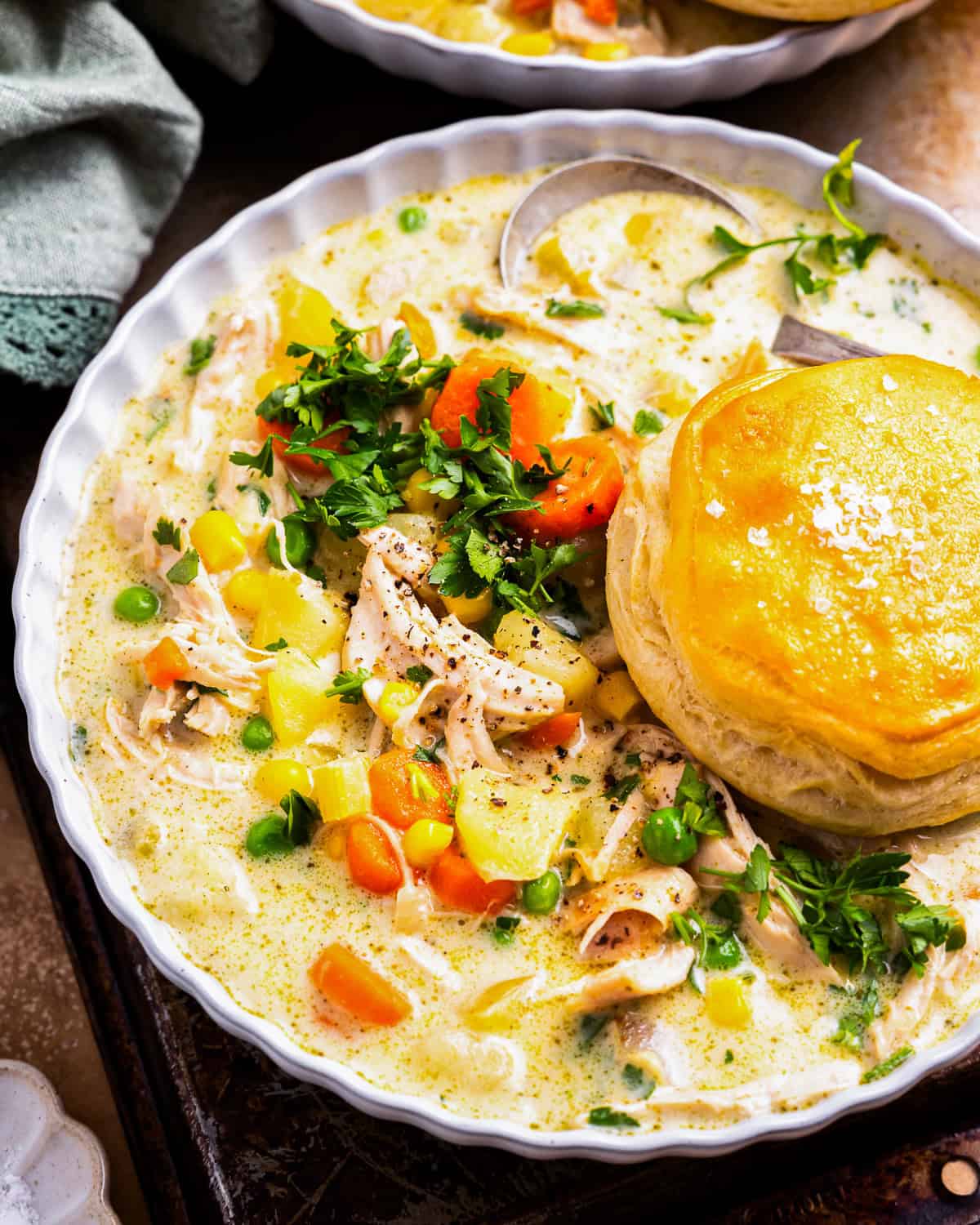 a serving of chicken pot pie soup in a bowl with a biscuit.