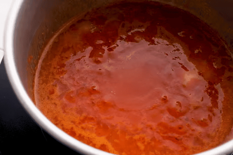 Buffalo sauce simmering in a pot.