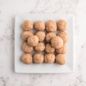 chicken meatballs on a white plate before cooking