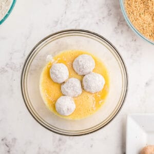 5 chicken meatballs rolled in flour and placed in a bowl of scrambled eggs