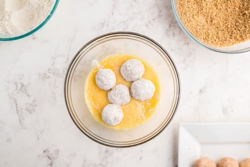 5 chicken meatballs rolled in flour and placed in a bowl of scrambled eggs