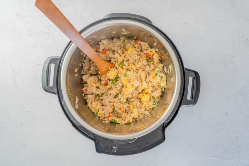 chicken fried rice in instant pot with a wood spoon