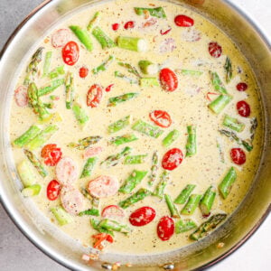 tomatoes, asparagus, and cream sauce in a skillet