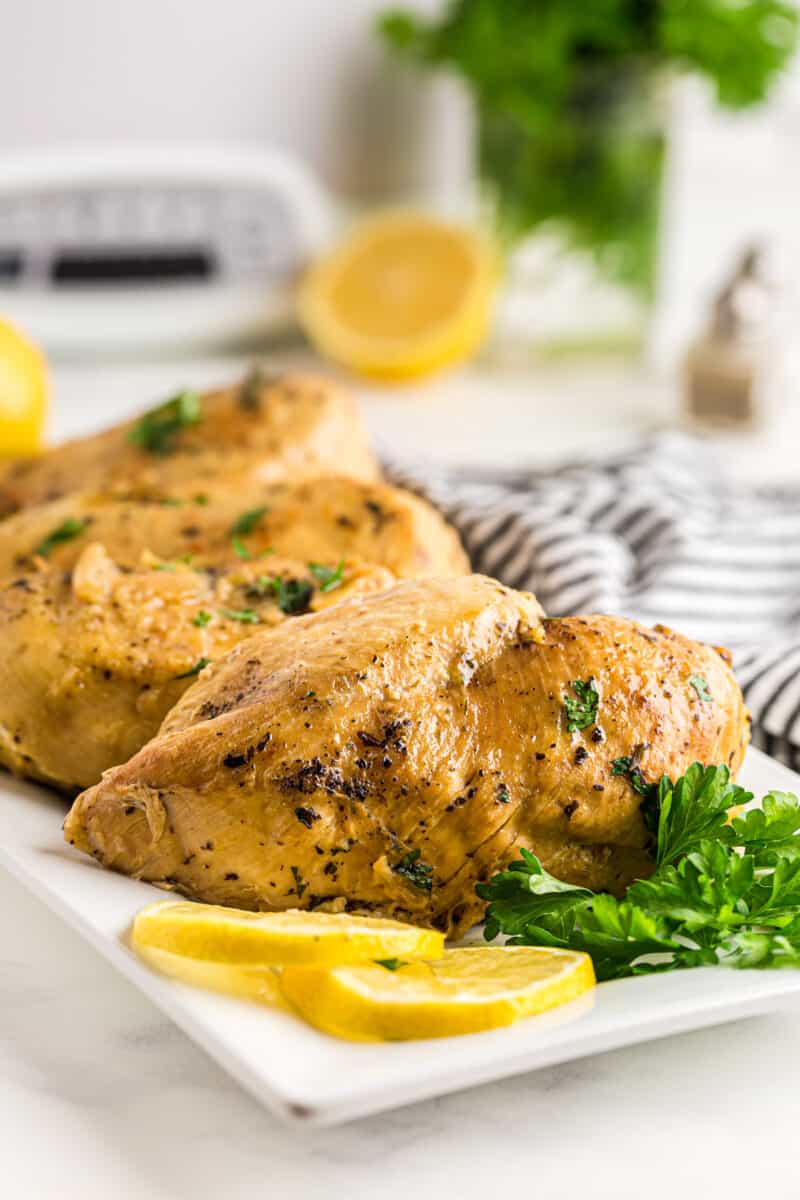 lemon herb chicken breasts on a white serving plate