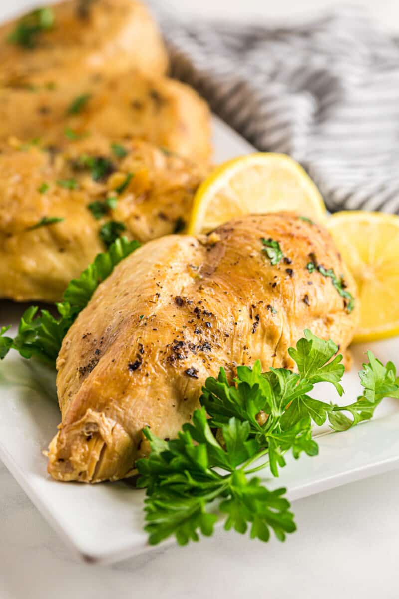 lemon herb chicken breasts on a white serving plate