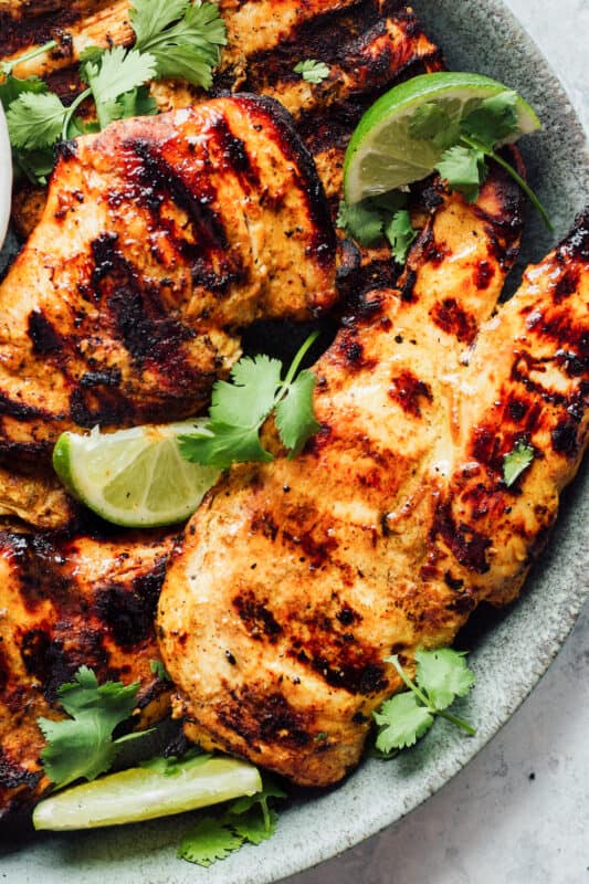 grilled tandoori chicken breasts on a gray plate