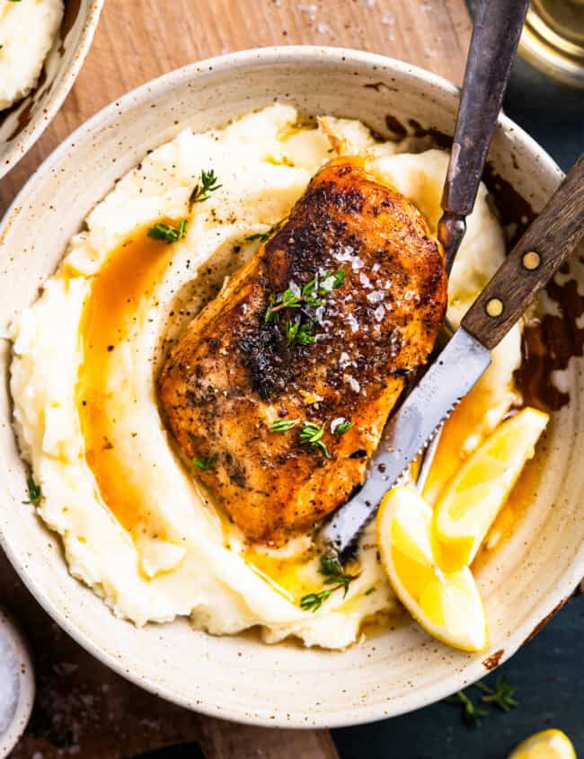 overhead view of a serving of crockpot lemon chicken over mashed potatoes.