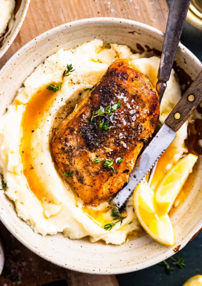 overhead view of a serving of crockpot lemon chicken over mashed potatoes.