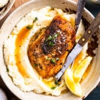 overhead view of a serving of crockpot lemon chicken over mashed potatoes.