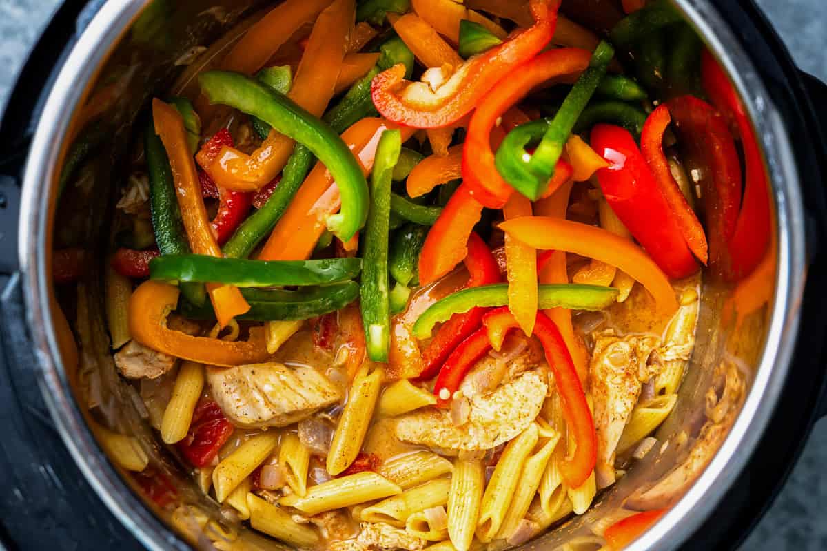 sliced peppers added to chicken fajita pasta in an instant pot.