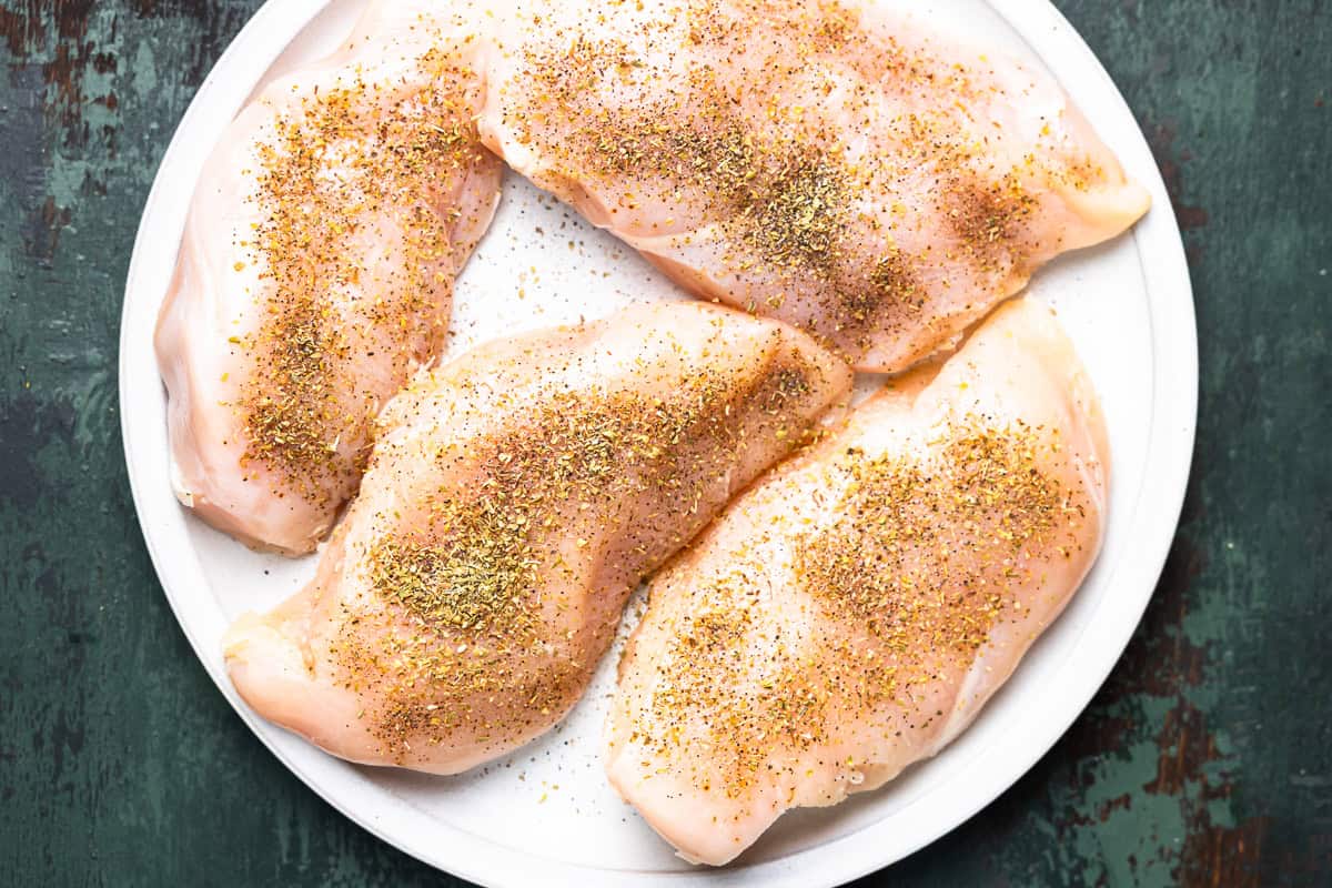 seasoned chicken breasts on a white plate.