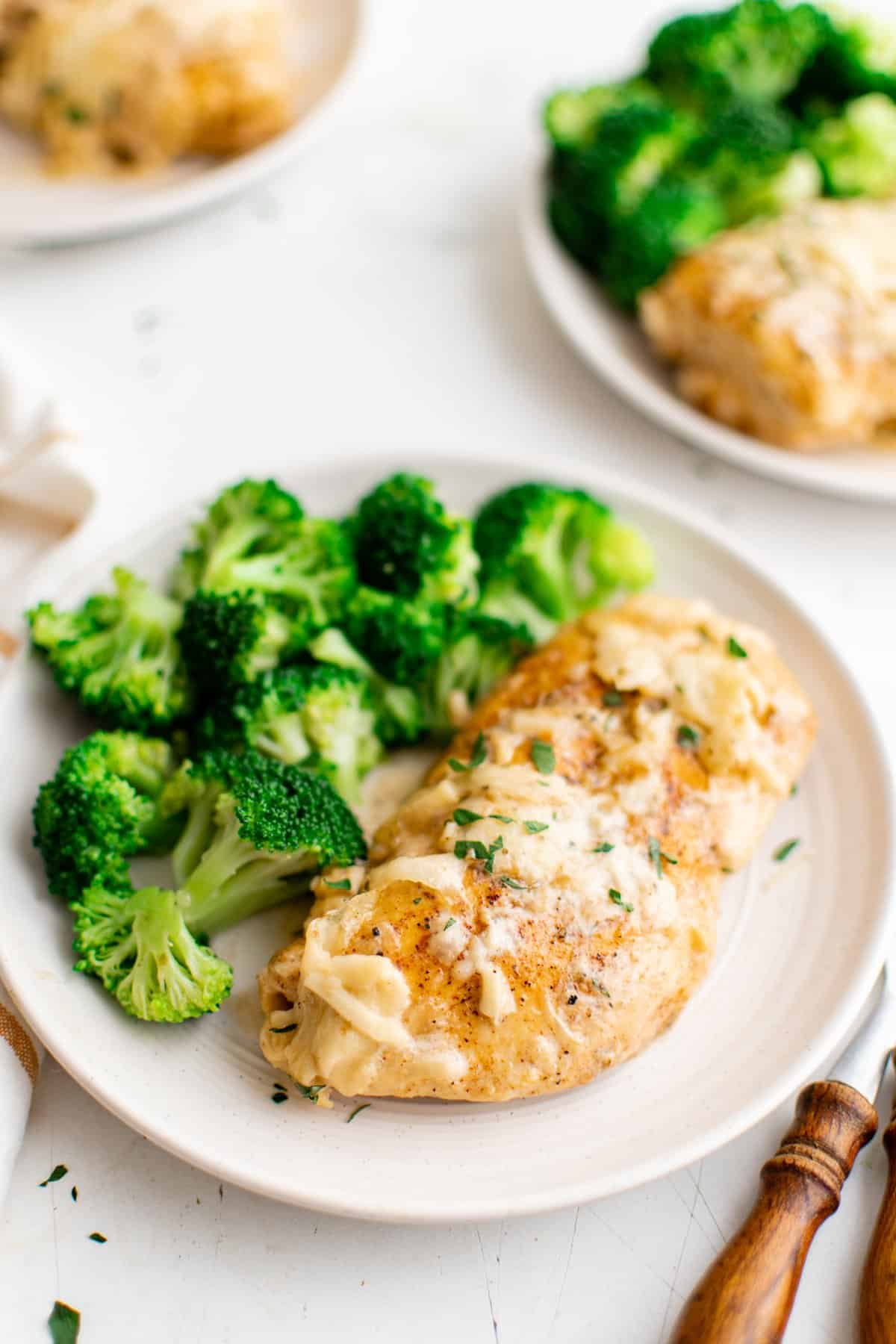 caesar chicken breast on a plate with broccoli