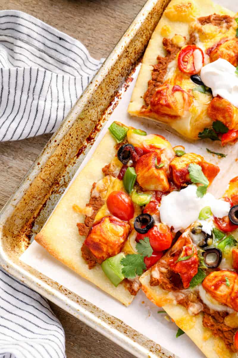 slices of chicken taco pizza on a baking sheet