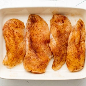 4 seasoned chicken breasts in a baking dish