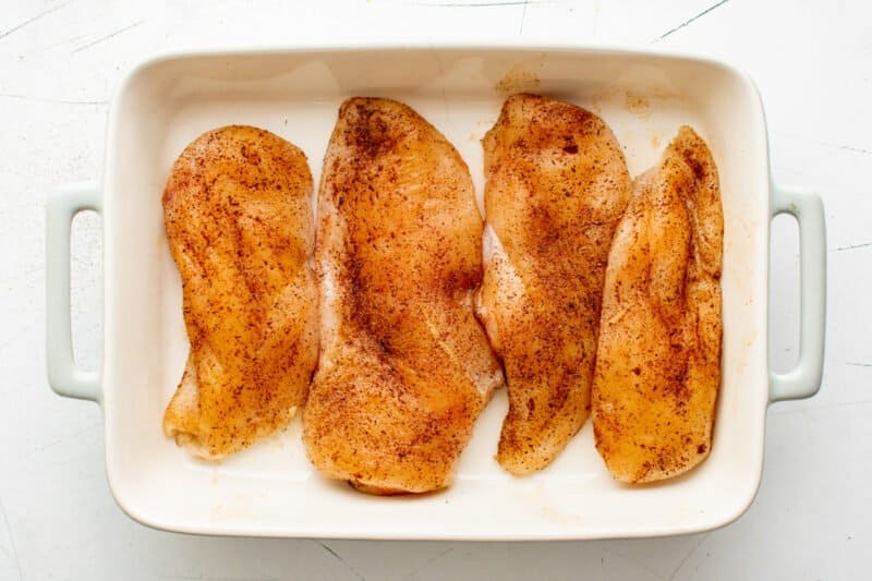 4 seasoned chicken breasts in a baking dish