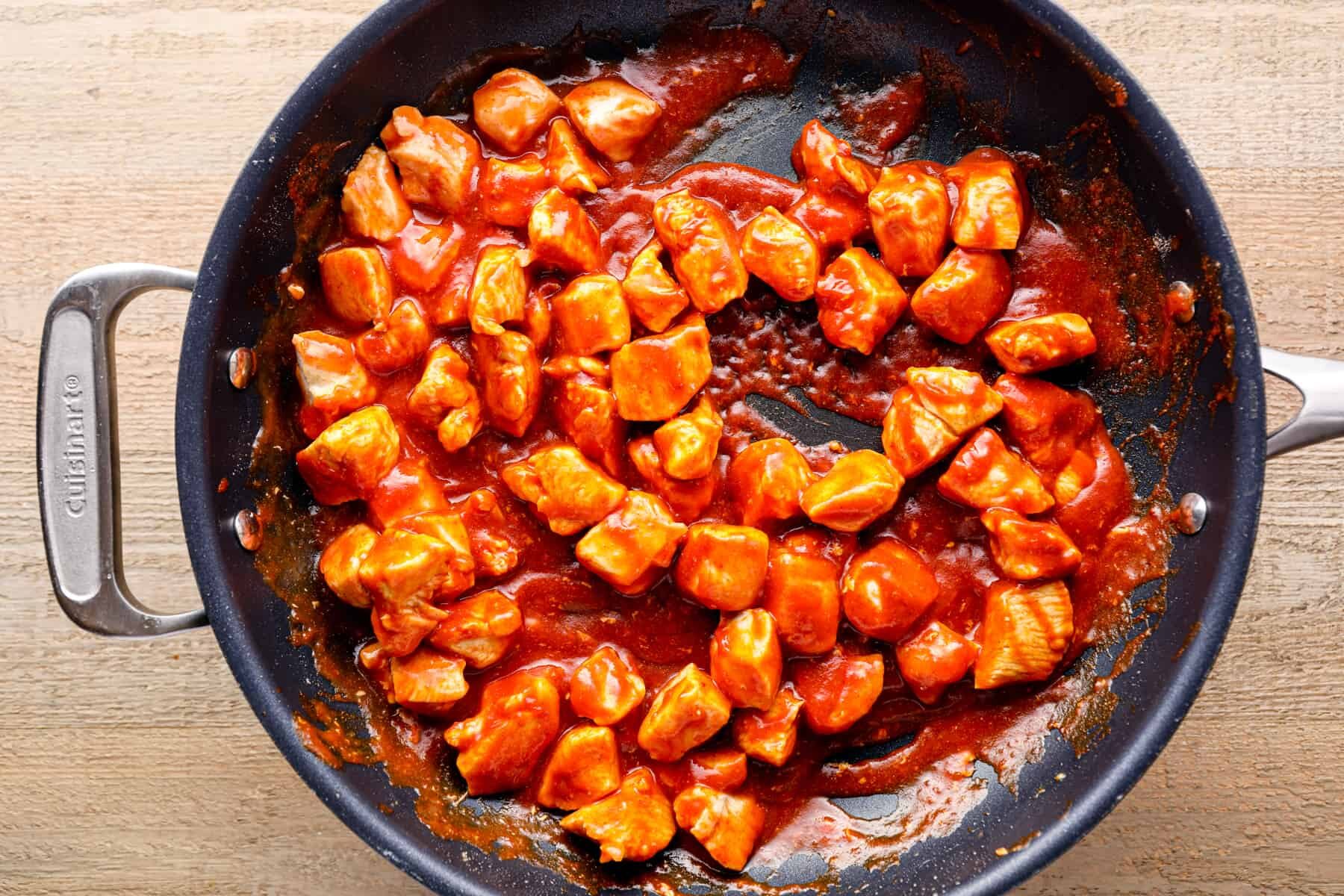 chicken with taco sauce and taco seasoning in a skillet