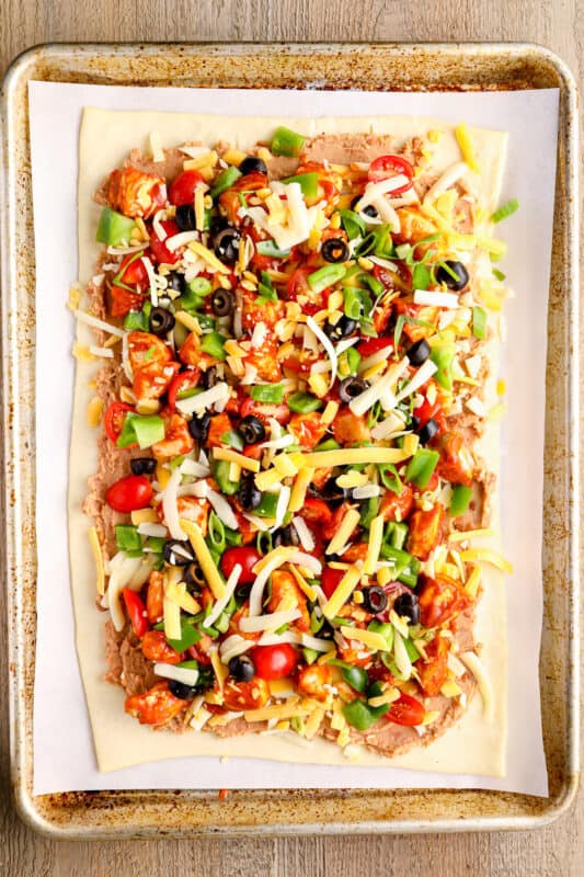 chicken taco pizza on a baking sheet before baking