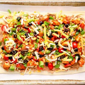 chicken taco pizza on a baking sheet before baking