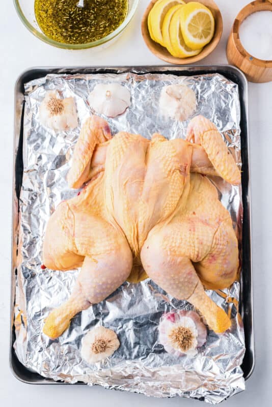 spatchcock chicken on a baking sheet