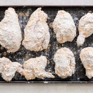 marinated chicken with flour on a cooling rack