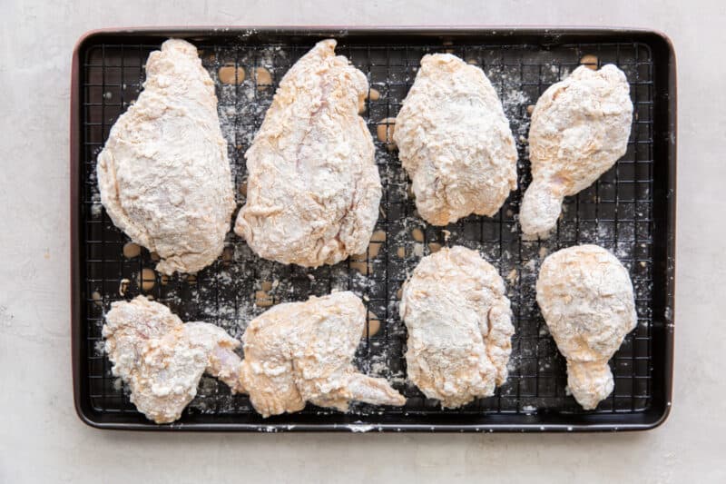 marinated chicken with flour on a cooling rack