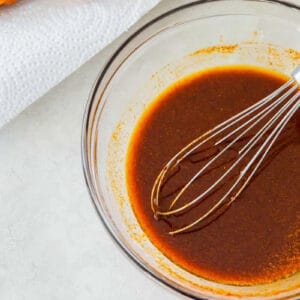 nashville hot sauce in a glass bowl with a whisk.