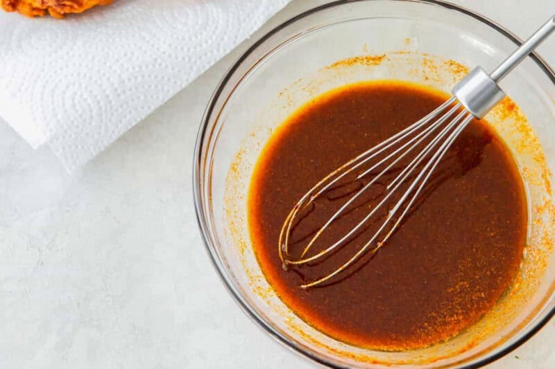 nashville hot sauce in a glass bowl with a whisk.