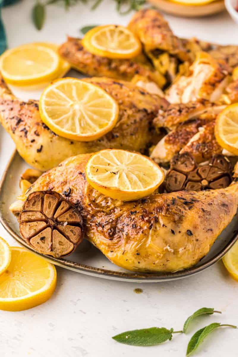 lemon garlic spatchcock chicken on a plate with lemon slices