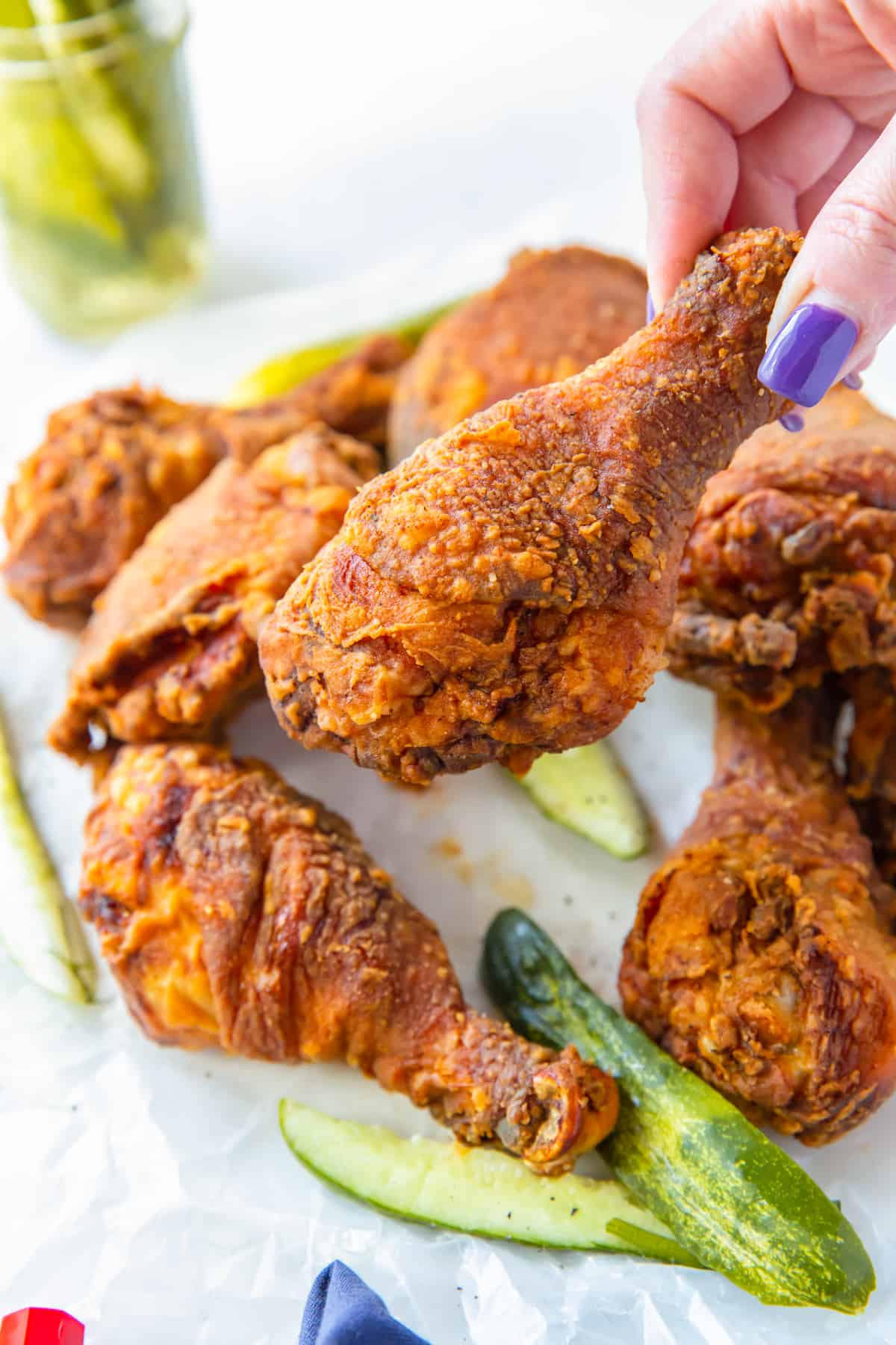 hand holding a pickle brined fried chicken drumstick