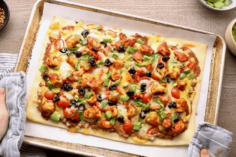 Freshly baked chicken taco pizza on a baking tray.