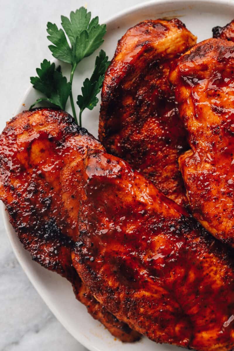BBQ chicken breasts on a white plate