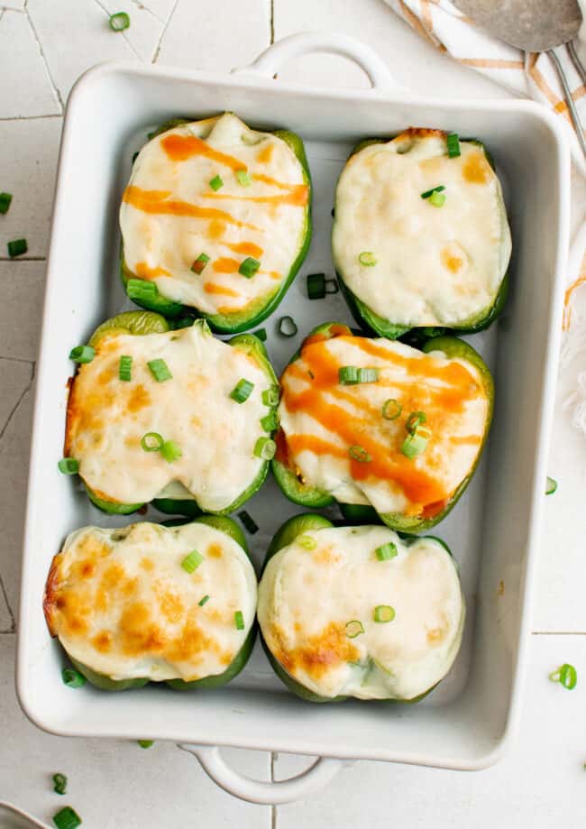 buffalo chicken stuffed peppers in a white baking dish after baking