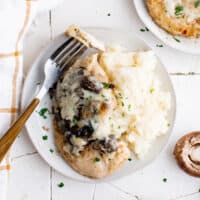 overhead image of a serving of chicken lombardy on a white plate with a fork