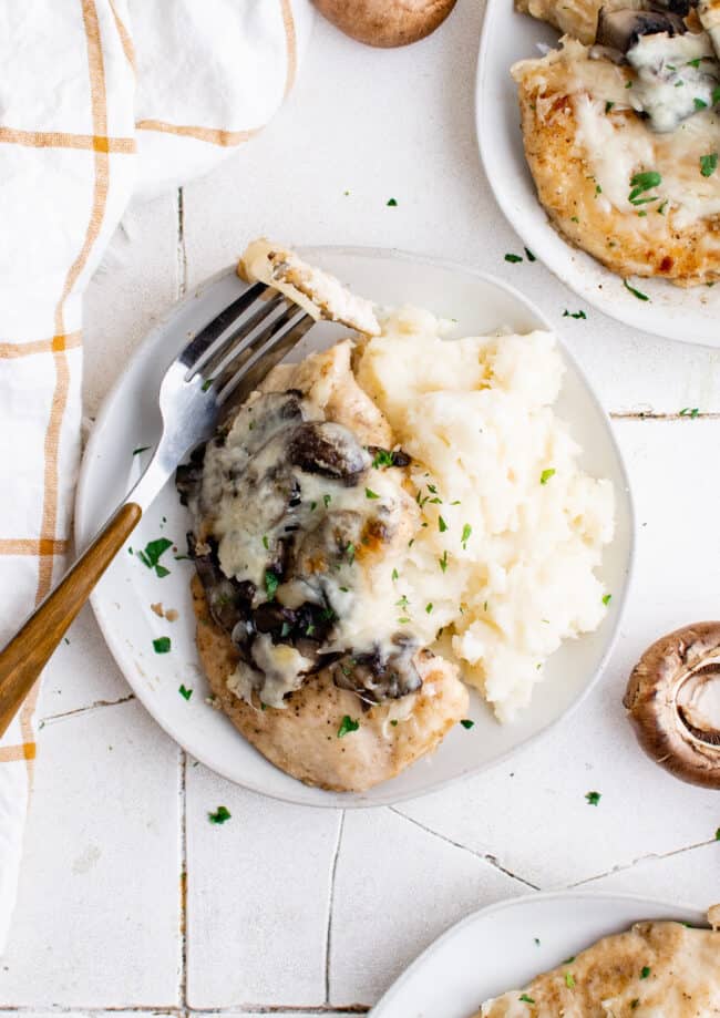 overhead image of a serving of chicken lombardy on a white plate with a fork