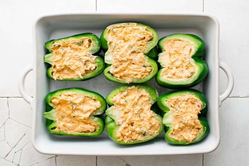 6 buffalo chicken stuffed peppers in a white baking dish