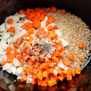 veggies, seasonings, and rice in a crockpo