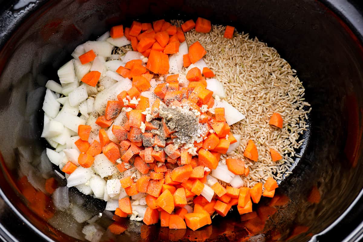 veggies, seasonings, and rice in a crockpo