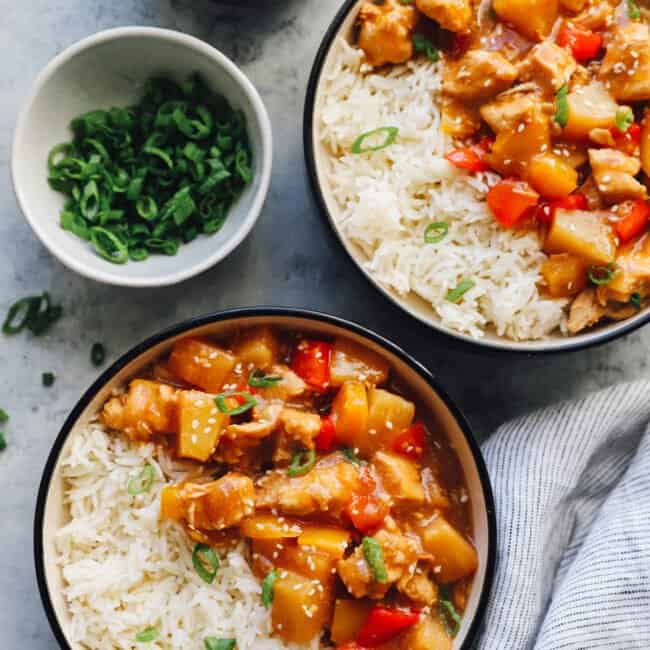 crockpot hawaiian chicken in black and white bowls with rice.
