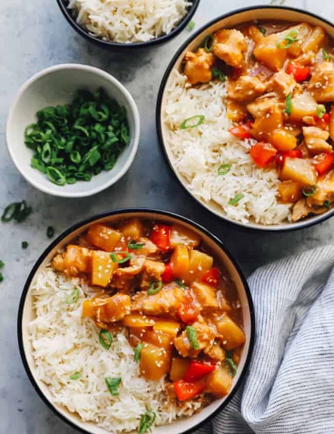 crockpot hawaiian chicken in black and white bowls with rice.