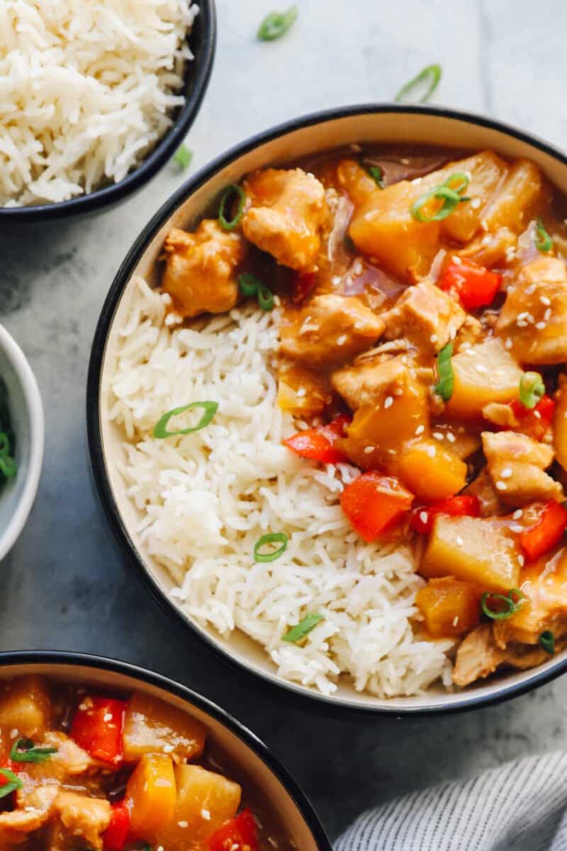 crockpot hawaiian chicken in a black and white bowl with rice.