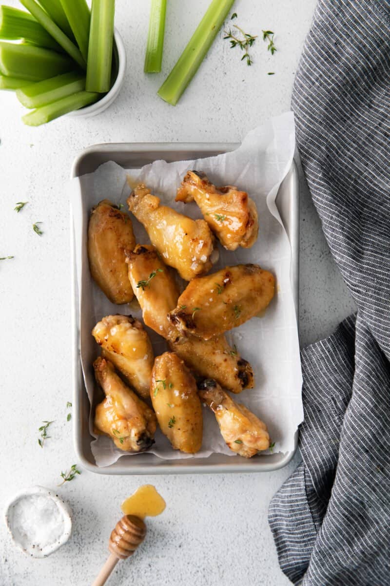 overhead view of 10 hot honey chicken wings on a baking sheet.