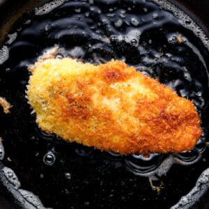 chicken katsu frying in a skillet.